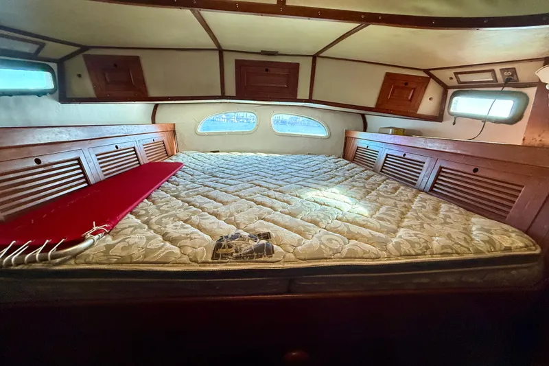 Slide: The Image of Interior cabin of 1981 Mariner Mayflower boat with bed and wooden storage. - 28