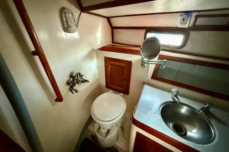 Slide: The Image of 1981 Mariner Mayflower yacht bathroom with toilet, sink, and mirror. - 33