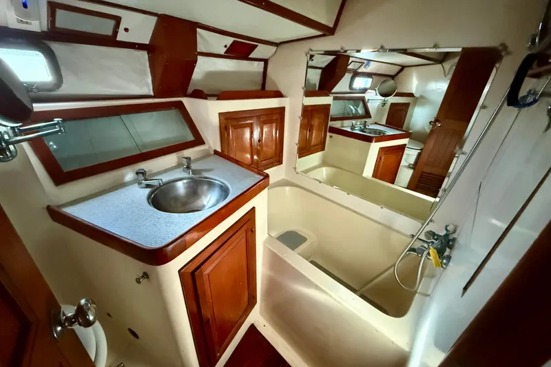 Slide: The Image of 1981 Mariner Mayflower yacht bathroom with sink, mirror, and wooden cabinetry. - 34