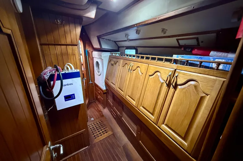 Slide: The Image of 1981 Mariner Mayflower yacht interior with wooden cabinetry and washing machine. - 35