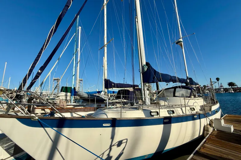 Slide: The Image of 1981 Mariner Mayflower sailboat docked at marina under clear blue sky. - 4