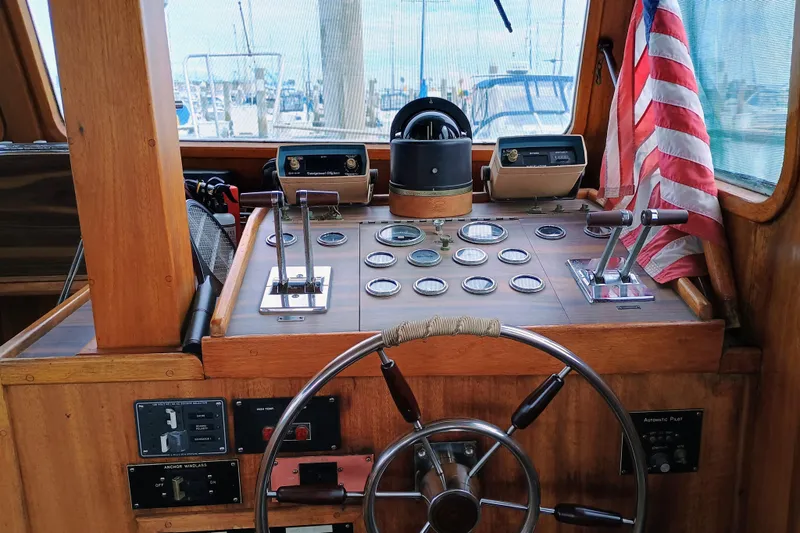 Slide: The Image of 1978 Californian LRC boat helm with wooden dashboard, steering wheel, and American flag. - 15