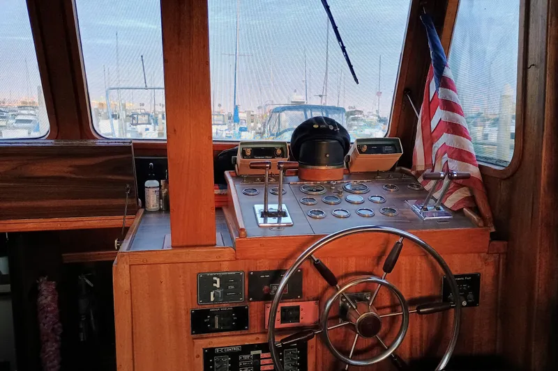 Slide: The Image of 1978 Californian LRC boat helm with wooden dashboard and American flag in marina setting. - 21