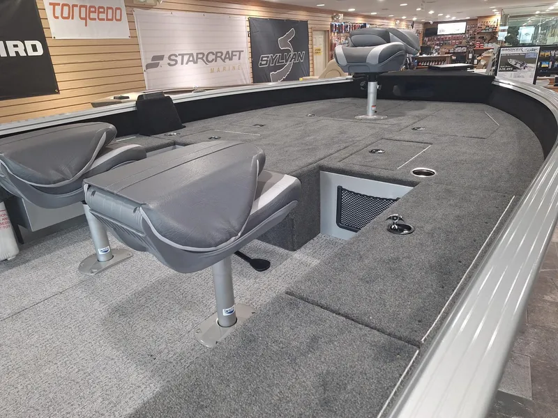 Slide: The Image of 2025 Starcraft Delta 188 T boat interior with gray seating and carpeted deck. - 16