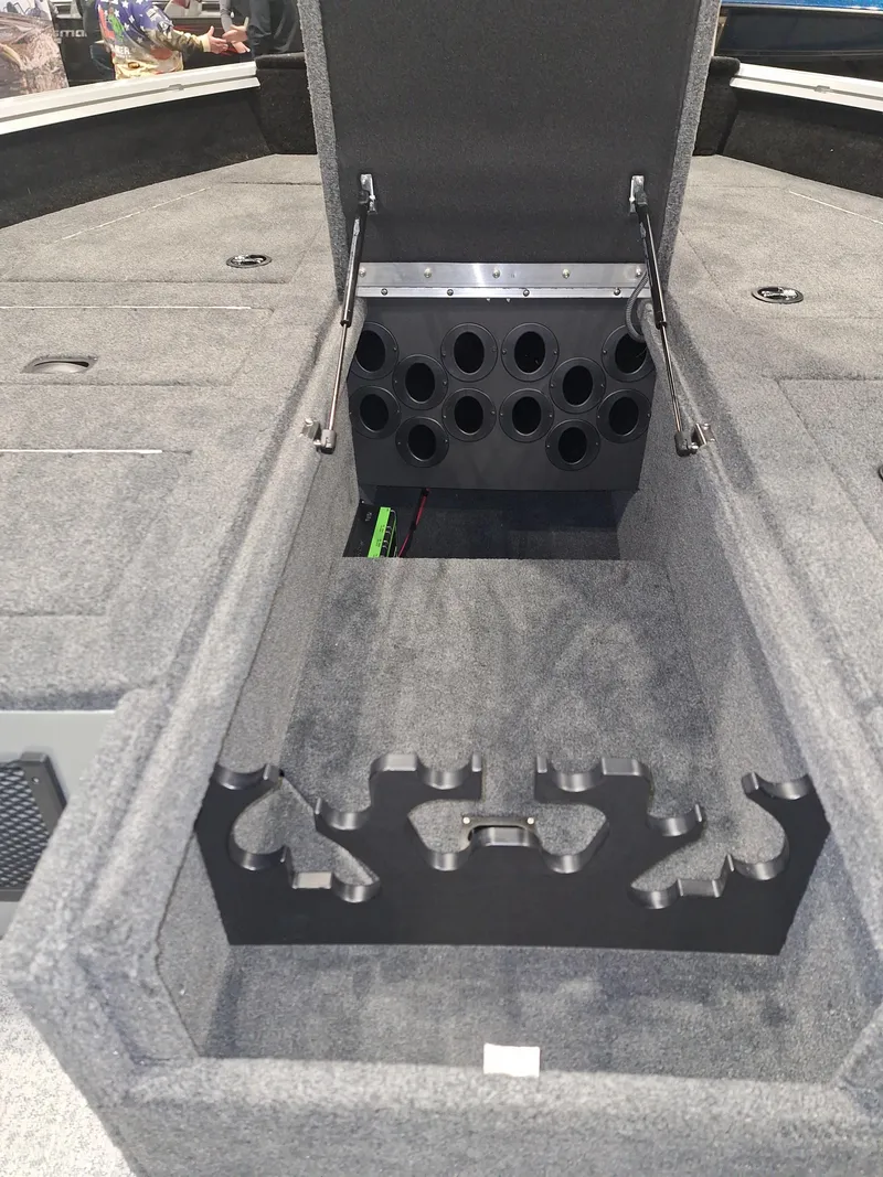 Slide: The Image of Storage compartment in 2025 Starcraft Delta 188 T boat, featuring rod holders and carpeted interior. - 5
