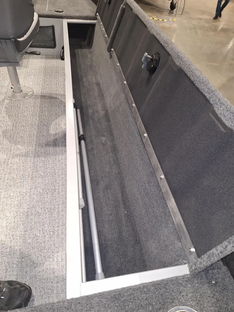 Slide: The Image of 2025 Starcraft Delta 188 T boat interior storage compartment with gray carpeting. - 6