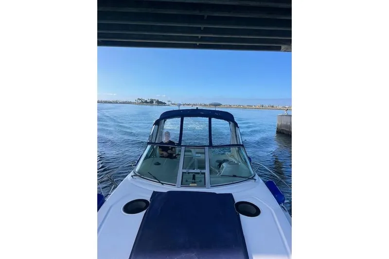 Slide: The Image of 2005 Searay 320 boat navigating under a bridge on a sunny day. - 1