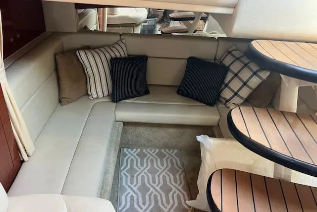 Slide: The Image of Interior of 2005 Searay 320 boat with cozy seating and decorative pillows. - 11
