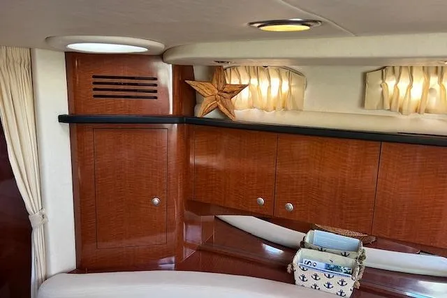 Slide: The Image of 2005 Searay 320 yacht interior with polished wood cabinets and nautical decor. - 9