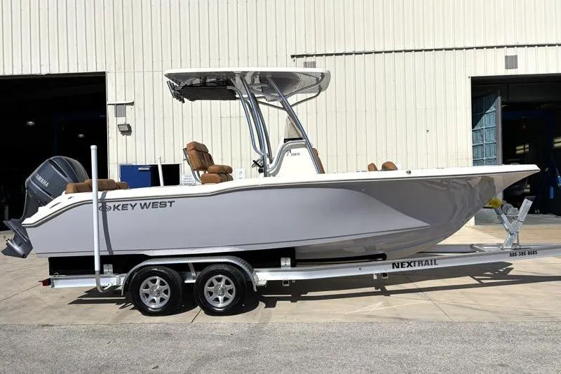 The Image of 2025 Key West 239 FS boat on trailer, parked outside a warehouse. - 0