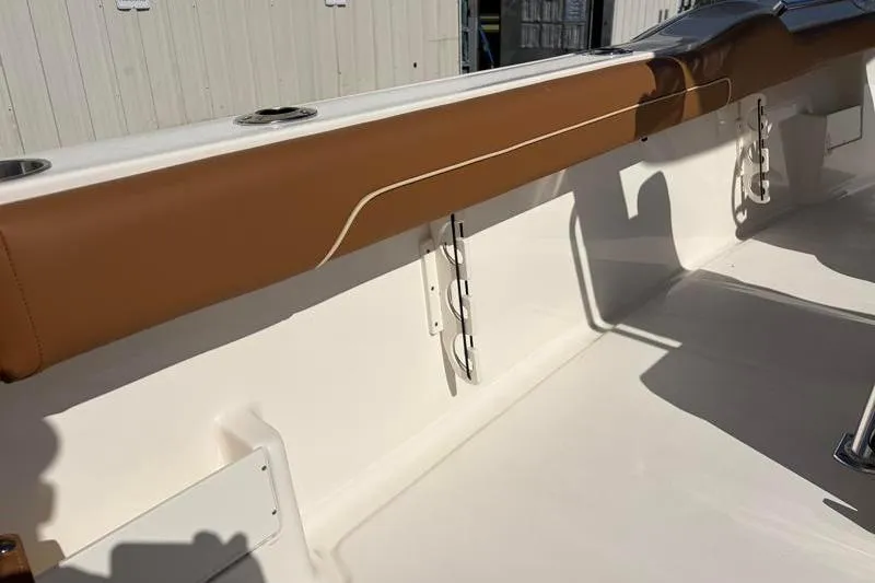 Slide: The Image of 2025 Key West 239 FS boat interior with tan upholstery and rod holders. - 44