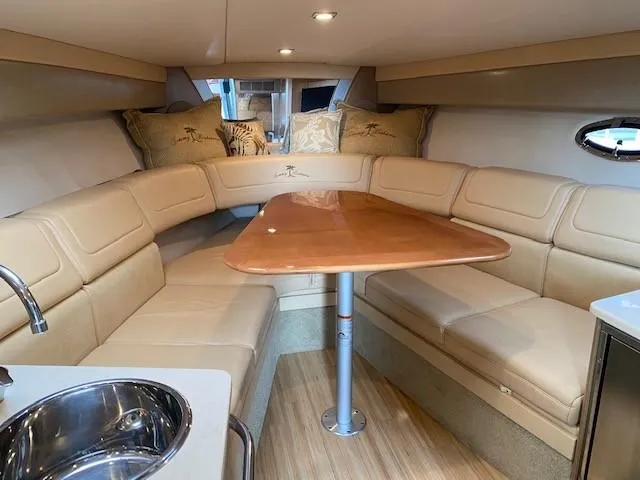 Slide: The Image of Interior of 2012 Formula 350 Sun Sport boat with beige seating and wooden table. - 15