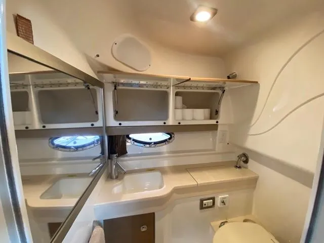 Slide: The Image of 2012 Formula 350 Sun Sport boat bathroom with sink, mirror, and storage shelves. - 22