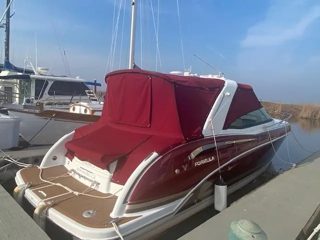 Slide: The Image of 2012 Formula 350 Sun Sport boat docked with red canopy, sleek design, and wooden deck. - 39