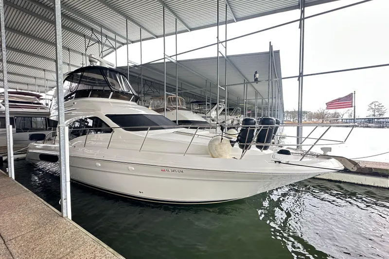 The Image of 2005 Sea Ray 420 Sedan Bridge yacht docked under a covered marina. - 0
