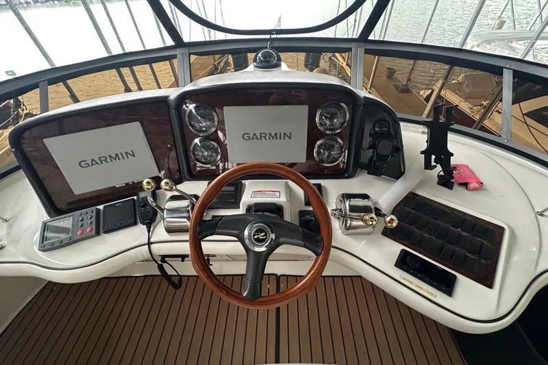 Slide: The Image of 2005 Sea Ray 420 Sedan Bridge helm with Garmin navigation displays and wooden steering wheel. - 11