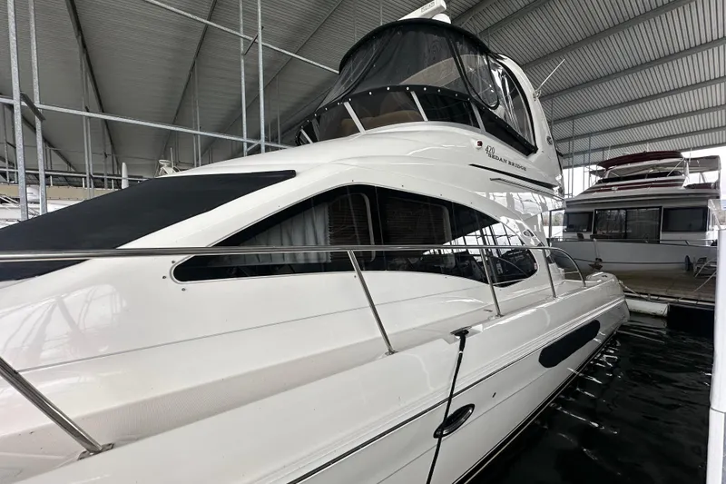 Slide: The Image of 2005 Sea Ray 420 Sedan Bridge yacht docked in a covered marina. - 2