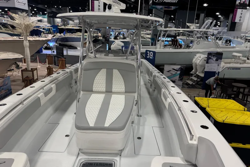 Slide: The Image of 2026 Contender 39 ST boat displayed at an indoor boat show, featuring sleek design and seating. - 23