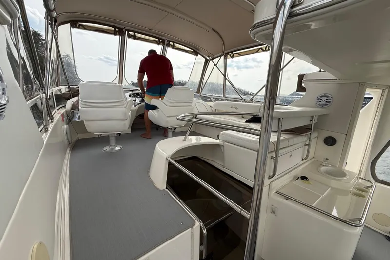 Slide: The Image of 1996 Sea Ray 420 Aft Cabin interior with helm, seating, and panoramic windows. - 10