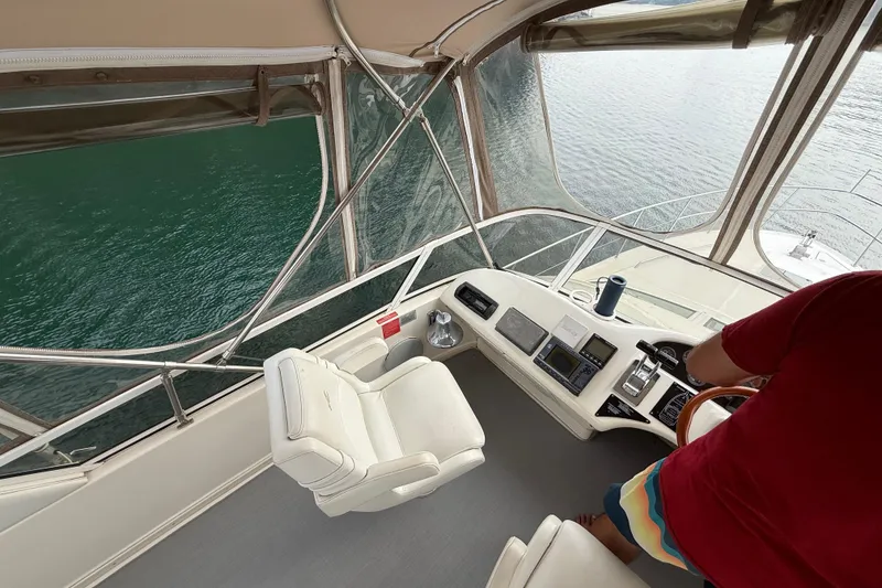 Slide: The Image of 1996 Sea Ray 420 Aft Cabin helm with steering controls and water view. - 12