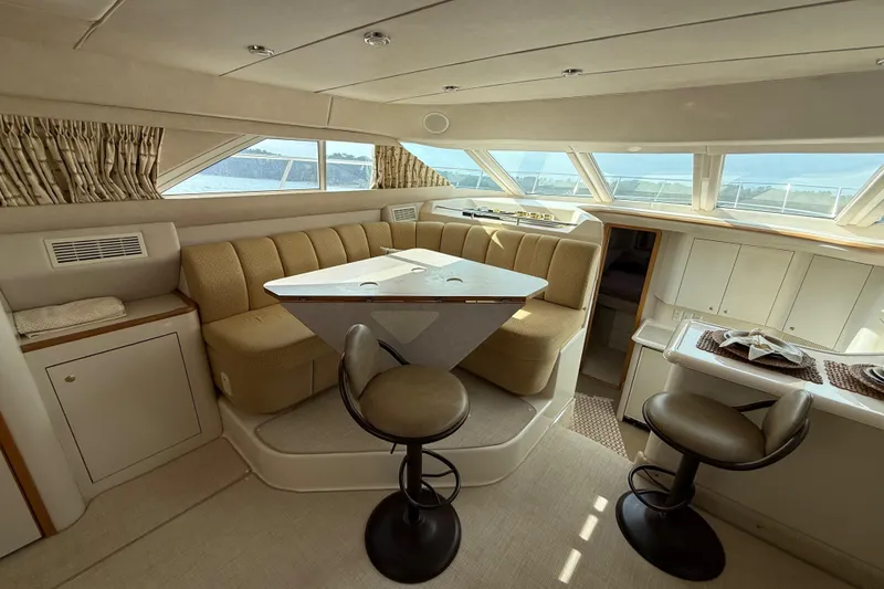 Slide: The Image of Luxurious interior of 1996 Sea Ray 420 Aft Cabin yacht with elegant seating and dining area. - 18