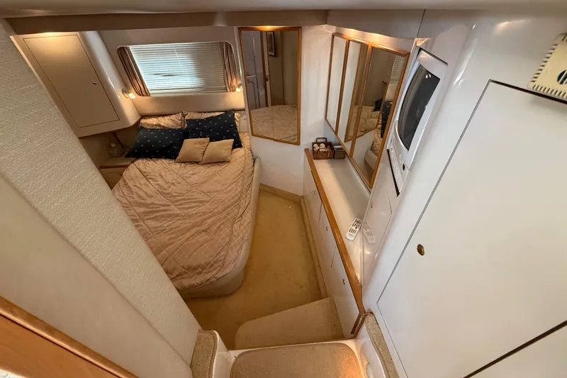 Slide: The Image of Luxurious 1996 Sea Ray 420 Aft Cabin bedroom with cozy bed and elegant decor. - 23