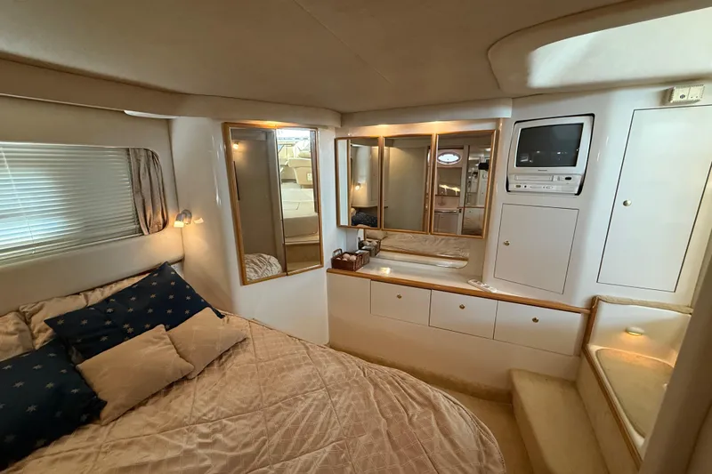 Slide: The Image of Luxurious interior of 1996 Sea Ray 420 Aft Cabin with cozy bed and built-in TV. - 27