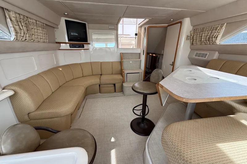 Slide: The Image of Luxurious interior of 1996 Sea Ray 420 Aft Cabin yacht with beige seating and dining area. - 37