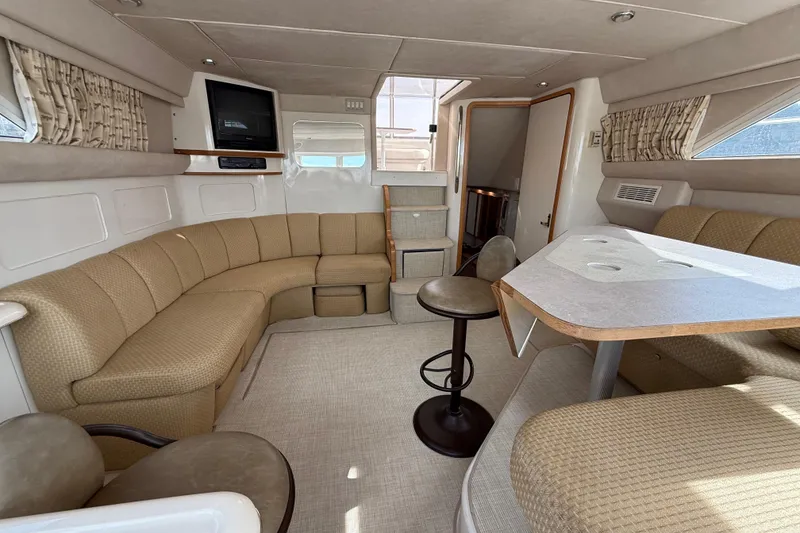 Slide: The Image of Interior of 1996 Sea Ray 420 Aft Cabin yacht with beige seating and dining area. - 38