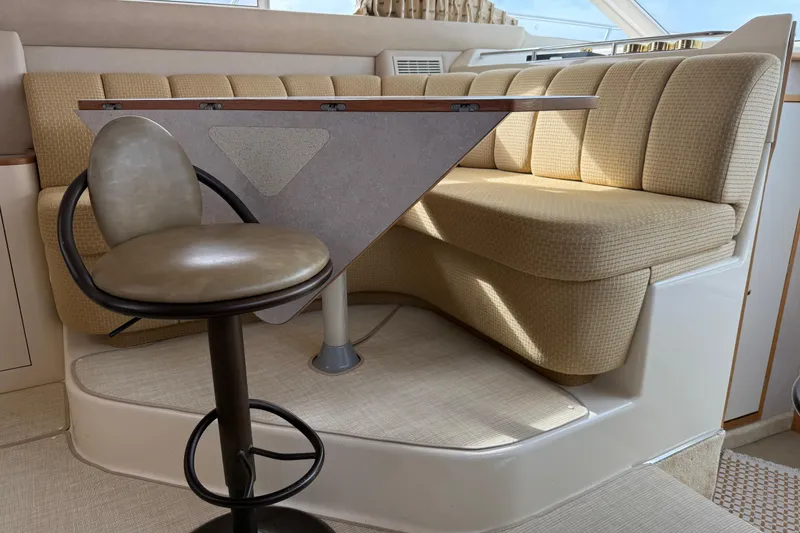 Slide: The Image of Interior of 1996 Sea Ray 420 Aft Cabin with beige seating and a modern table. - 39
