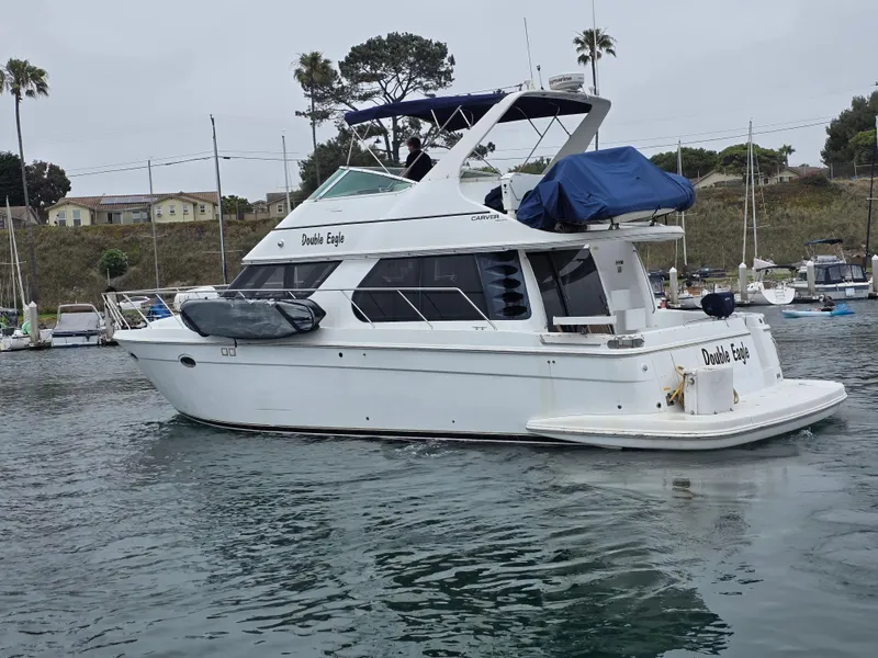 Slide: The Image of 2000 Carver 450 Voyager Pilothouse yacht docked in a marina, side view. - 15