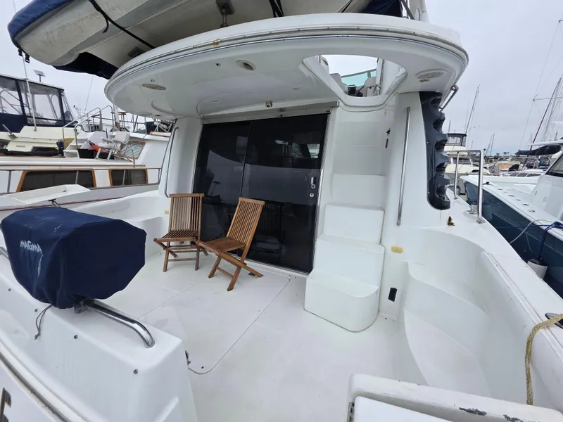 Slide: The Image of 2000 Carver 450 Voyager Pilothouse yacht with seating on deck, docked at marina. - 17
