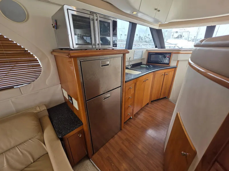 Slide: The Image of Interior of 2000 Carver 450 Voyager Pilothouse with kitchen appliances and wooden cabinetry. - 23