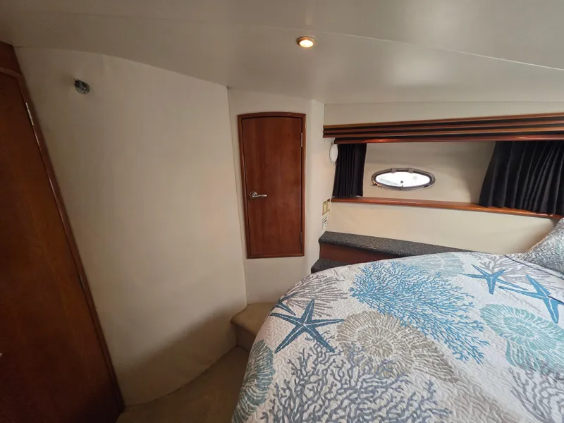 Slide: The Image of Interior of 2000 Carver 450 Voyager Pilothouse with cozy bedroom and nautical-themed bedding. - 26