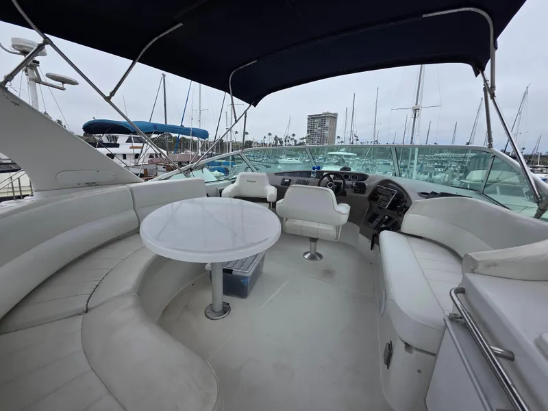 Slide: The Image of 2000 Carver 450 Voyager Pilothouse yacht interior with seating and helm, docked at marina. - 33