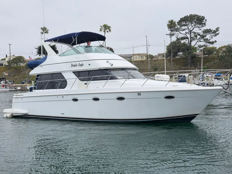 The Image of 2000 Carver 450 Voyager Pilothouse yacht docked in a marina. - 12