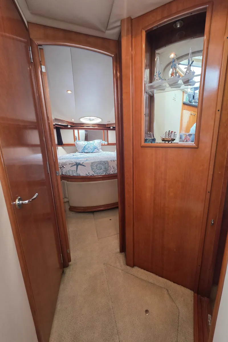 Slide: The Image of Interior hallway of 2000 Carver 450 Voyager Pilothouse yacht, featuring wood paneling and bedroom view. - 28