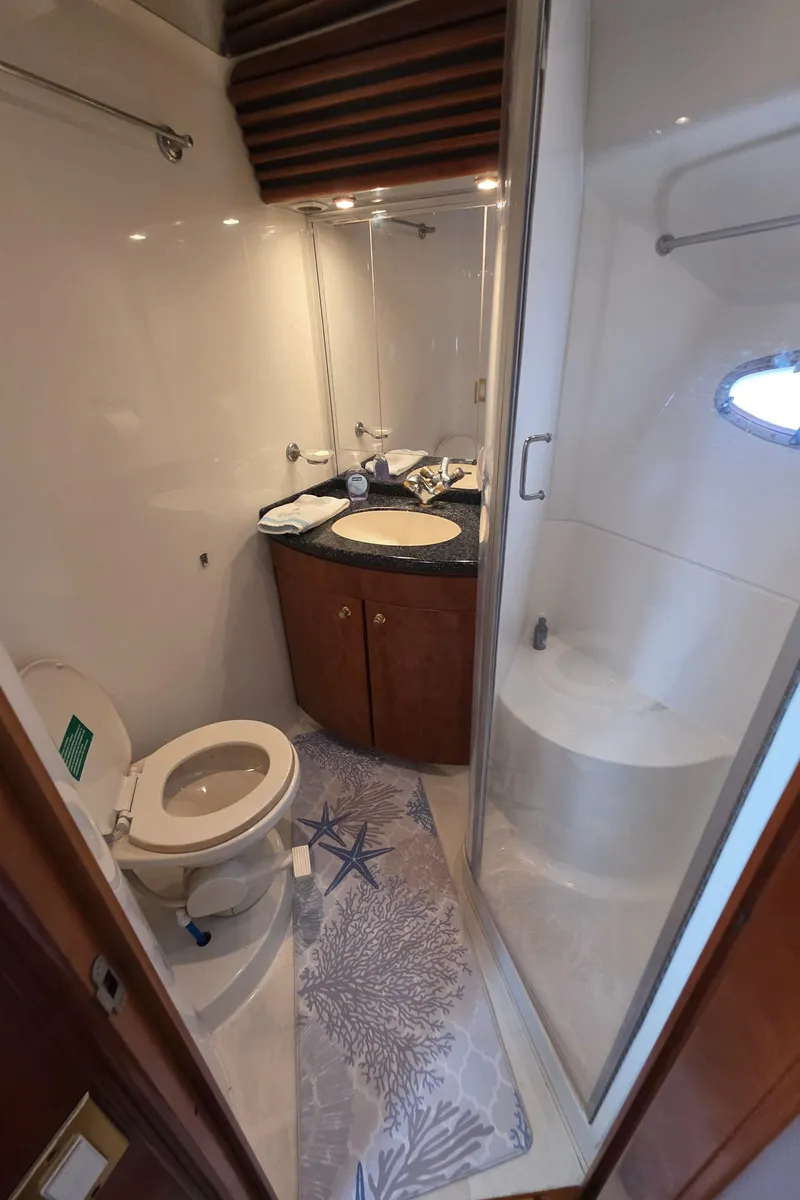 Slide: The Image of Bathroom interior of 2000 Carver 450 Voyager Pilothouse yacht, featuring toilet, sink, and shower. - 32