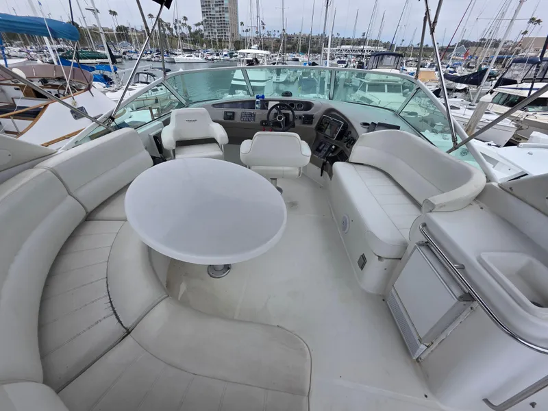 Slide: The Image of 2000 Carver 450 Voyager Pilothouse yacht interior with seating and helm, docked at marina. - 34