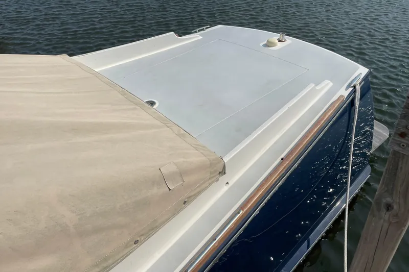 Slide: The Image of 2009 Landing School Arrundel 27 boat docked on calm water, partially covered. - 26