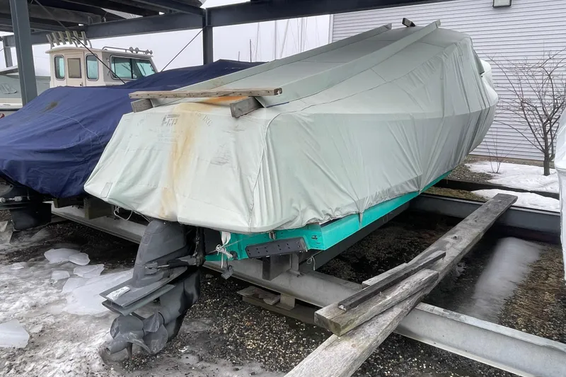 Slide: The Image of Covered 2009 Landing School Arundel 27 boat on trailer in snowy storage area. - 30