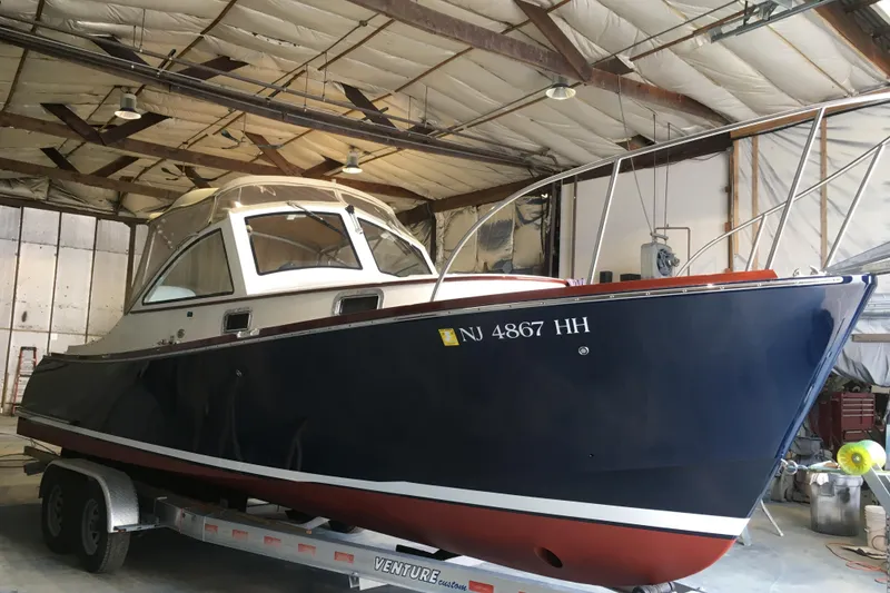 Slide: The Image of 2009 Landing School Arrundel 27 boat in a warehouse on a trailer. - 4