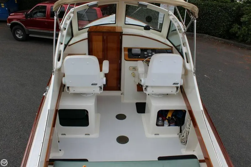 Slide: The Image of 2009 Landing School Arrundel 27 boat interior with dual white seats and control panel. - 8