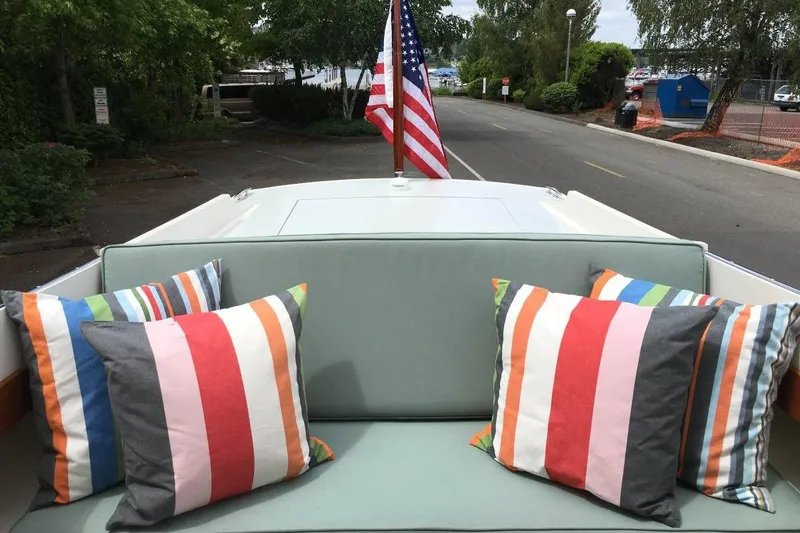 Slide: The Image of Cozy seating on 2009 Landing School Arrundel 27 boat with striped pillows and American flag. - 9