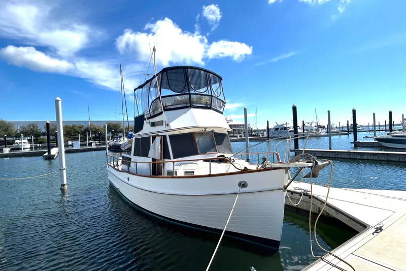 Slide: The Image of 1988 Grand Banks 36 Classic yacht docked at marina under clear blue sky. - 1
