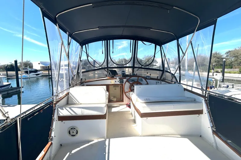 Slide: The Image of 1988 Grand Banks 36 Classic yacht interior with helm, seating, and marina view. - 12