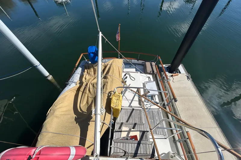 Slide: The Image of 1988 Grand Banks 36 Classic yacht docked, view from above, with covered deck and calm water. - 18