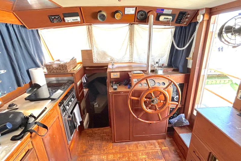 Slide: The Image of 1988 Grand Banks 36 Classic boat interior with wooden helm and kitchen area. - 19