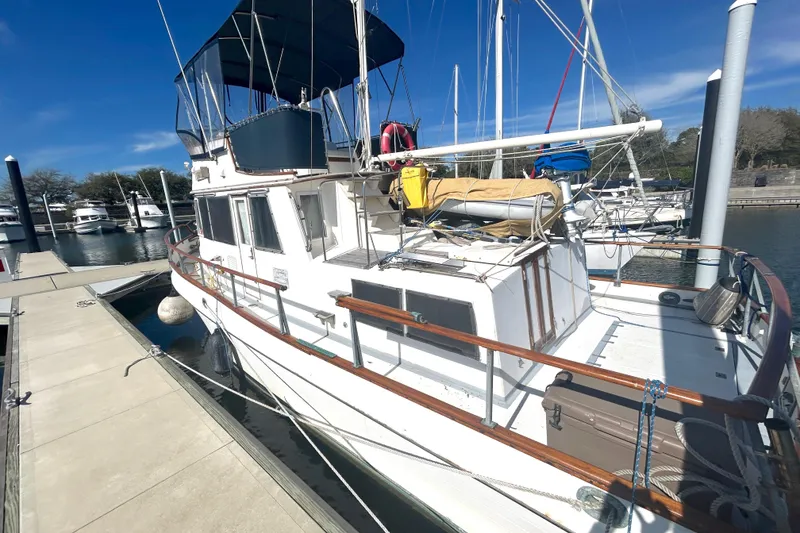 Slide: The Image of 1988 Grand Banks 36 Classic yacht docked at marina under clear blue sky. - 2