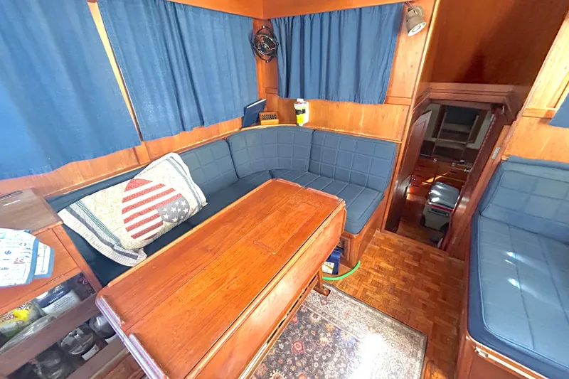 Slide: The Image of 1988 Grand Banks 36 Classic interior with blue seating, wooden table, and nautical decor. - 25